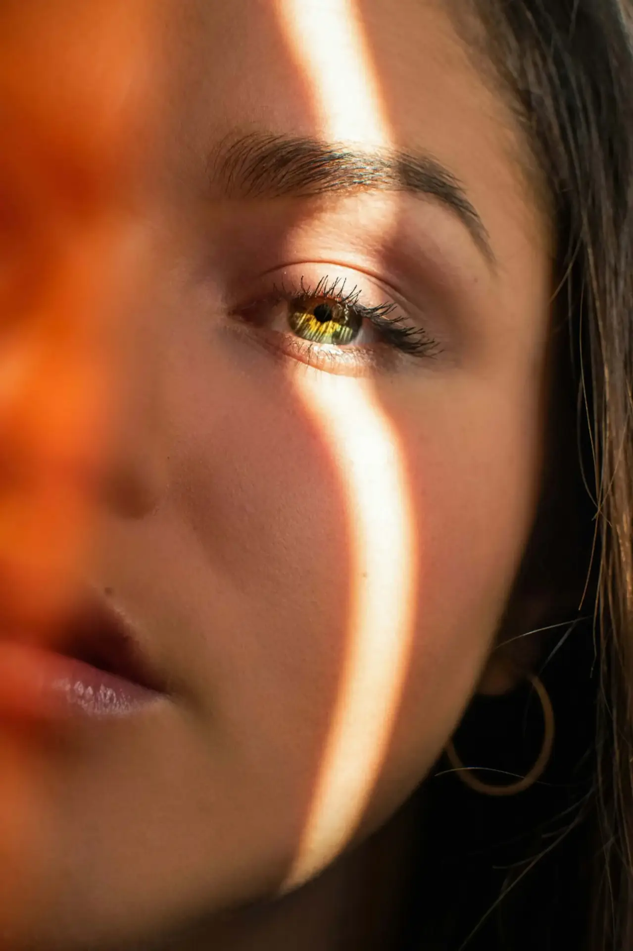 Nahaufnahme eines Gesichts mit einem Lichtstreifen über dem Auge